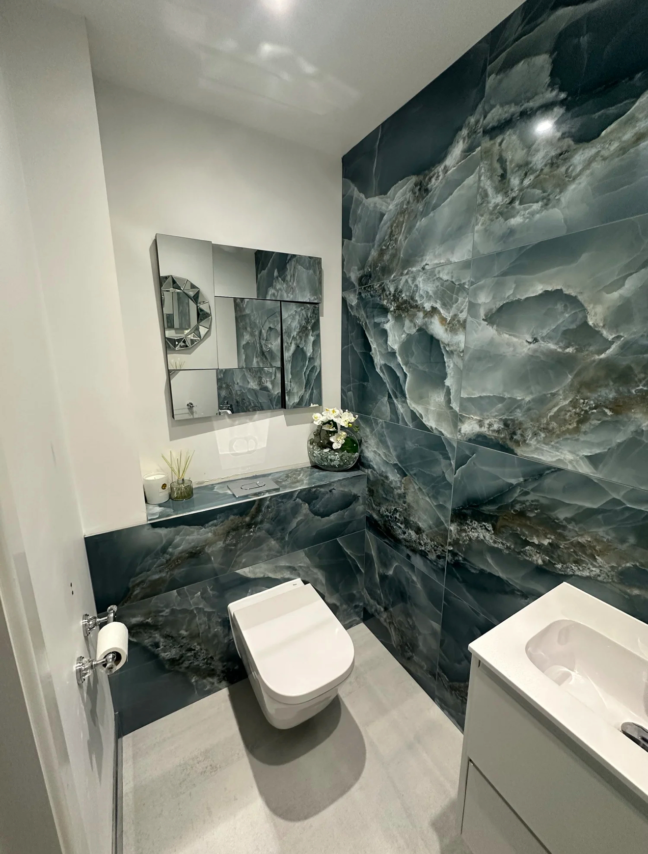 Luxury cloakroom with blue onyx-effect feature tiles and wall-hung WC in Reading