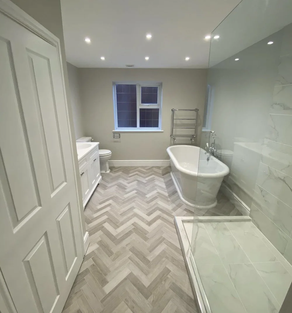 Traditional family bathroom with freestanding roll-top bath, herringbone floor and marble walk-in shower — bathroom installation in Reading
