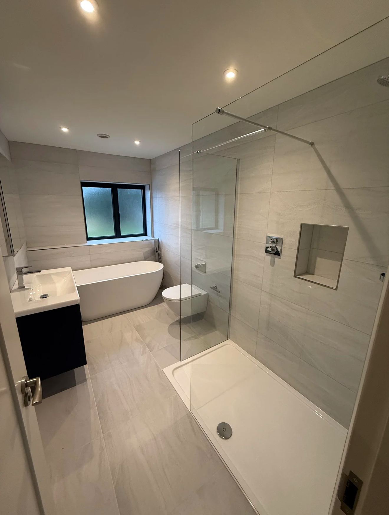 Modern family bathroom with walk-in shower, freestanding bath and floating vanity in Reading